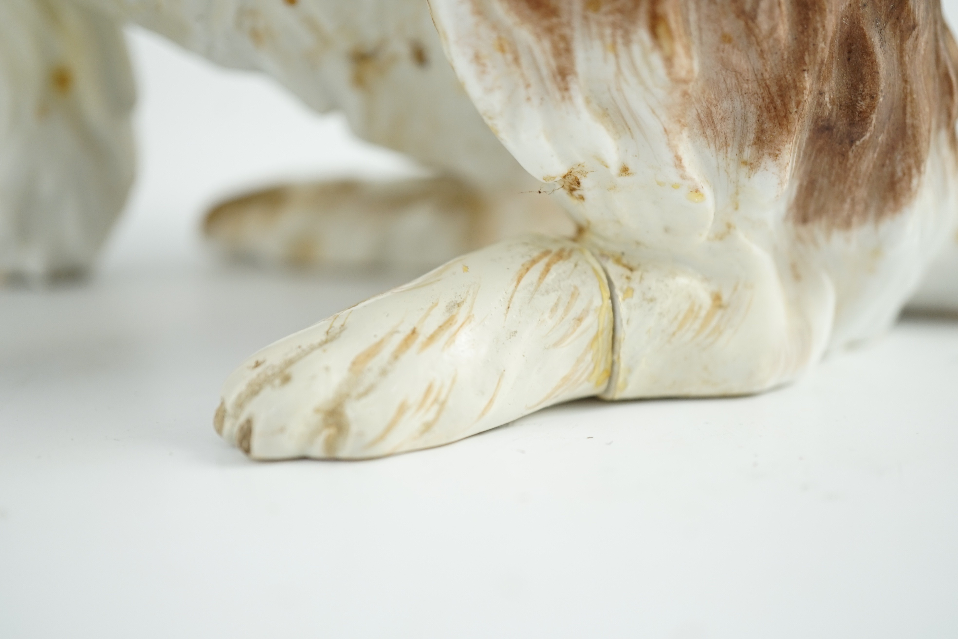 A Meissen seated figure of a German Wachtelhund (spaniel), 19th century, 19cm high, restoration and damage